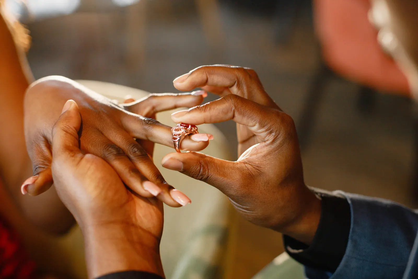 A couple exchanging an engagement ring in warm evening light