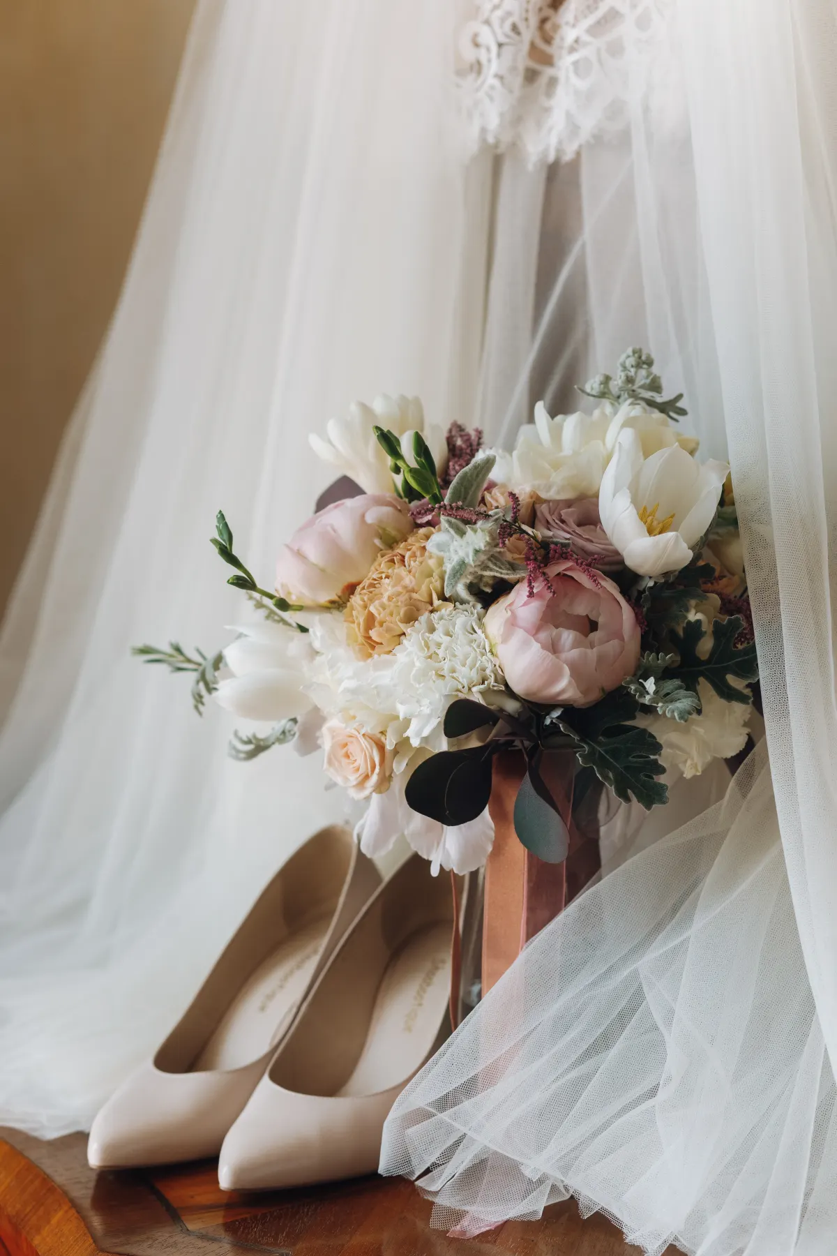 Wedding shoes, a bridal dress and a flower bouquet styled together